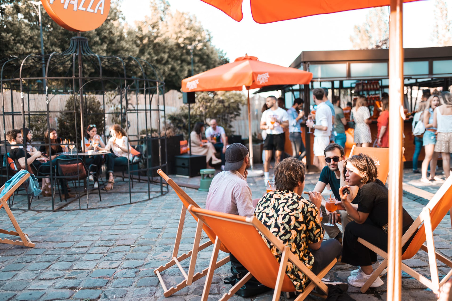 Groupe de personnes profitant d'une terrasse animée avec des boissons Aperol.